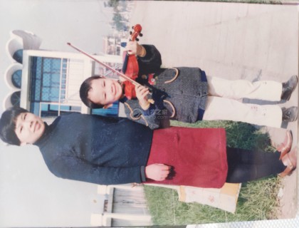 这是1995年上完小提琴课，回家的路上，在路边照相馆拍了一张合照，寄给当时在埃塞俄比亚工作的父亲