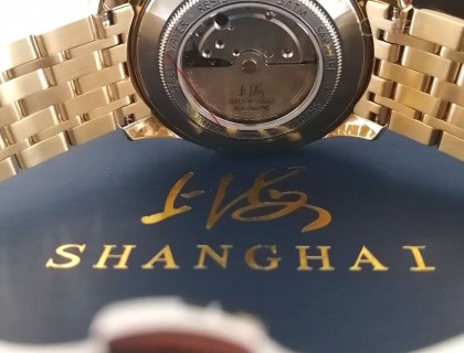 平置背面，日产机芯 摆陀上却印着“上海”标记……